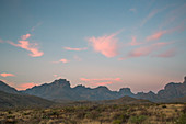 A Mountain Range In The Distance Under A Softly Glowing Dawn Sky