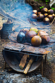 Coconuts Are Grilled Over A Wood Fire