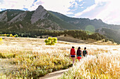 A Female Hikers Walk On A Trail Beneath The Flatirons In Colorado