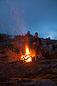 Portrait Of A Climber Keeping Warm Beside An Alpine Bonfire