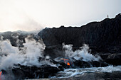 A Hiker Pauses On The Edge Of The Kalapana Lava That Has Been Flowing Into The Ocean