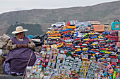 Traditional miniature cars and money thought to give good luck for sale at a stall in the resort of Copacabana on Lake Titicaca, Bolivia, South America