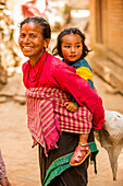 Woman carrying her child in Bhaktapur, Kathmandu, Nepal, Asia