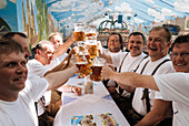 Männer mittleren Alters stossen mit Bierkrügen an, Oktoberfest, München, Oberbayern, Bayern, Deutschland