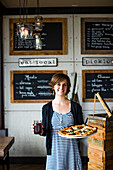 A young woman serves pizza and beer at a restaurant in Long Beach, WA.