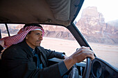 Portrait of a Bedouin man driving his jeep in the desert, Wadi Rum, Jordan.