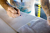 Surfboard Shaper Marking The Length Of Surfboard With Pencil