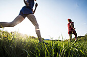 Two Female Runners Running On Grassy Field