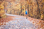 Woman Running On Foggy Road During Autumn