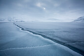A Cut In The Pack Ice Leading To Snowy Mountains In The Background In Spitsbergen, Svalbard