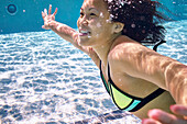 Young Woman Swimming Underwater In The Pool