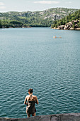 Young Woman Wrapped In Towel While A Canoe Is Crossing The Lake