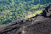 A Young Athletic Female Trail Runner Running On The Black Sands Of The Pacaya Volcano, Guatemala