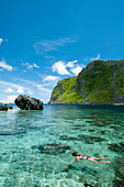 View Of Snorkeler Exploring The Tropical Reefs Of El Nido In The Philippines