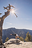 A Young Woman Practices Yoga On Top Of A Cliff In Yosemite National Park