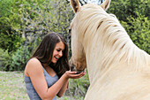 Happy Teenage Girl Holding Her Hands Out To A Horse