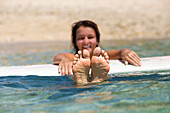 Smiling Surfer Float With Surfboard On Tropical Water