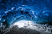Man inside an ice caver under the Vatnajokull glacier, Vatnajokull national park, East Iceland, Iceland , MR