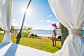 Playa Moron, Las Terrenas, Samana Peninsula, Dominican Republic,  Beautiful woman admiring the view from by a beach bed , MR