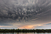 Rio negro waters depicted at sunset, with a strange cloud formation in the sky,  Amazonas, Manaus, Brazil, South America