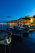 View of blue sea and boats surrounding the colorful village at dusk Portovenere province of La Spezia Liguria Italy Europe