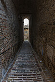 A typical alley and medieval walls of the old town of Fermo Marche Italy Europe