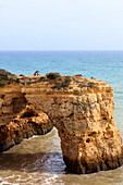 Woman practises gymnastics on the rocky cliffs Albandeira Lagoa Municipality Algarve Portugal Europe