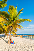 Mano Juan, Saona Island, Ost-Nationalpark, Parque Nacional del Este, Dominikanische Republik, Karibisches Meer, Frau entspannt auf dem Palmen gesäumten Strand, MR