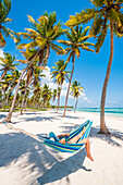 Canto de la Playa, Saona Island, Ost-Nationalpark, Parque Nacional del Este, Dominikanische Republik, Karibisches Meer, Frau entspannt auf einer Hängematte am Strand, MR