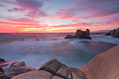 Rosa Himmel bei Sonnenuntergang auf den Wellen Absturz auf Klippen Capo Testa Santa Teresa di Gallura Provinz Sassari Sardinien Italien Europa