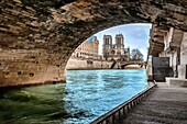 Notre Dame Cathedral view from under the bridge Saint Michel, River Seine and the Prefecture of Police, Paris, France