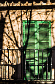 Ein typischer Balkon eines alten Hauses mit Baumschatten, Valldemossa, Mallorca, Spanien