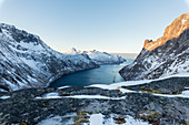 Draufsicht auf schneebedeckten Gipfeln und gefrorenem Meer des Ornfjorden um das Dorf Fjordgard, Senja, Troms, Norwegen, Skandinavien, Europa
