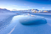 Photographer admires Lake, Piz Umbrail at dawn with Mount Ortles in background, Braulio Valley, Valtellina, Lombardy, Italy, Europe