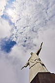 Low angle shot of the iconic statue of Christ the Redeemer on a cloudy day with sun shining through clouds, Rio de Janeiro, Brazil, South America