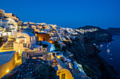 Der Blick von Oia Schloss entlang Santorini Caldera während der Abend blauen Stunde mit den Gebäuden beleuchtet, Santorini, Kykladen, griechische Inseln, Griechenland, Europa