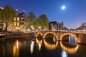 Dämmerlicht auf typischen Gebäuden und Brücken spiegelt sich in einem typischen Kanal, Amsterdam, Holland (Niederlande), Europa