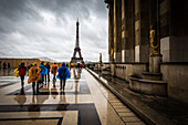Heading towards the Eiffel Tower, tourists brave the rain in colourful ponchos at the Palais De Chaillot, Paris, France, Europe
