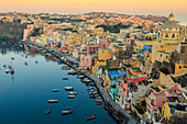 Marina Corricella at sunrise, fishing village, colourful houses, church and harbour boats, Procida Island, Bay of Naples, Campania, Italy, Europe
