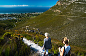 Zwei Frauen Wanderer gehen hinunter in Hermanus aus dem Berg, Hermanus, Südafrika, Afrika