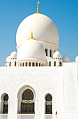 Innenraum der Scheich Zayed Grand Mosque, glänzend weiß von Marmorgebäuden unterbrochen von winzigen Frau in Rot, Abu Dhabi, Vereinigte Arabische Emirate, Mittlerer Osten