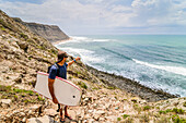 Bodyboarder checks the surf at a spot near Areia Branca, Portugal.