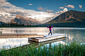Young girl runs along wharf at mountain lake