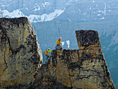 Mountaineering couple ascend rock pinnacle, mountains