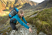 Weiblicher Wanderer kommt auf Berggipfel