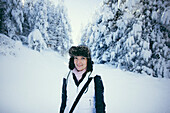 Porträt der Frau stehend im Wald im Schnee