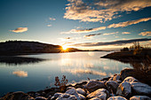 Sun rises over a lake after a dusting of snow the night before. Wyoming, United States