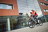 Mann und Frau auf eBike in der Stadt, München, Bayern, Deutschland