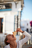 8jähriges Mädchen isst Pizzastück , Conil de la Frontera, Andalusien, Südwestküste Spanien, Atlantik, Europa