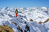 Woman backcountry skiing looking towards Glockner range with Grossglockner and Wiesbachhorn, Felskarspitze, Radstadt Tauern, Carinthia, Austria